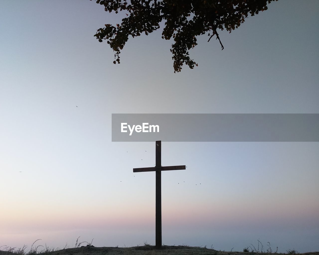 Low angle view of silhouette cross against sky during sunset