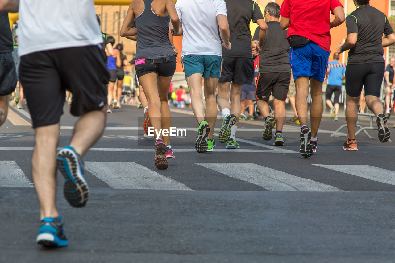 People running on road in city