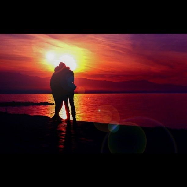 SILHOUETTE OF WOMAN IN SEA AT SUNSET