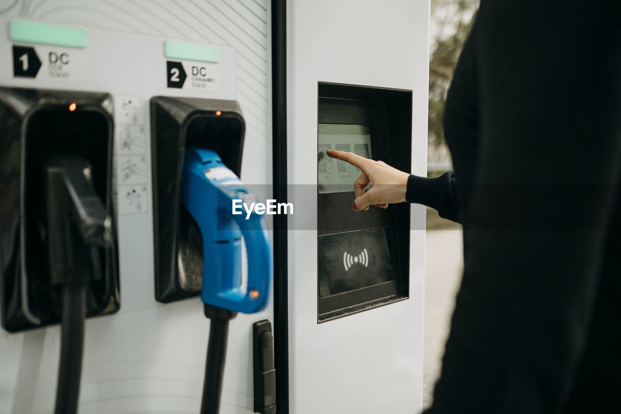 Man at electric charging station