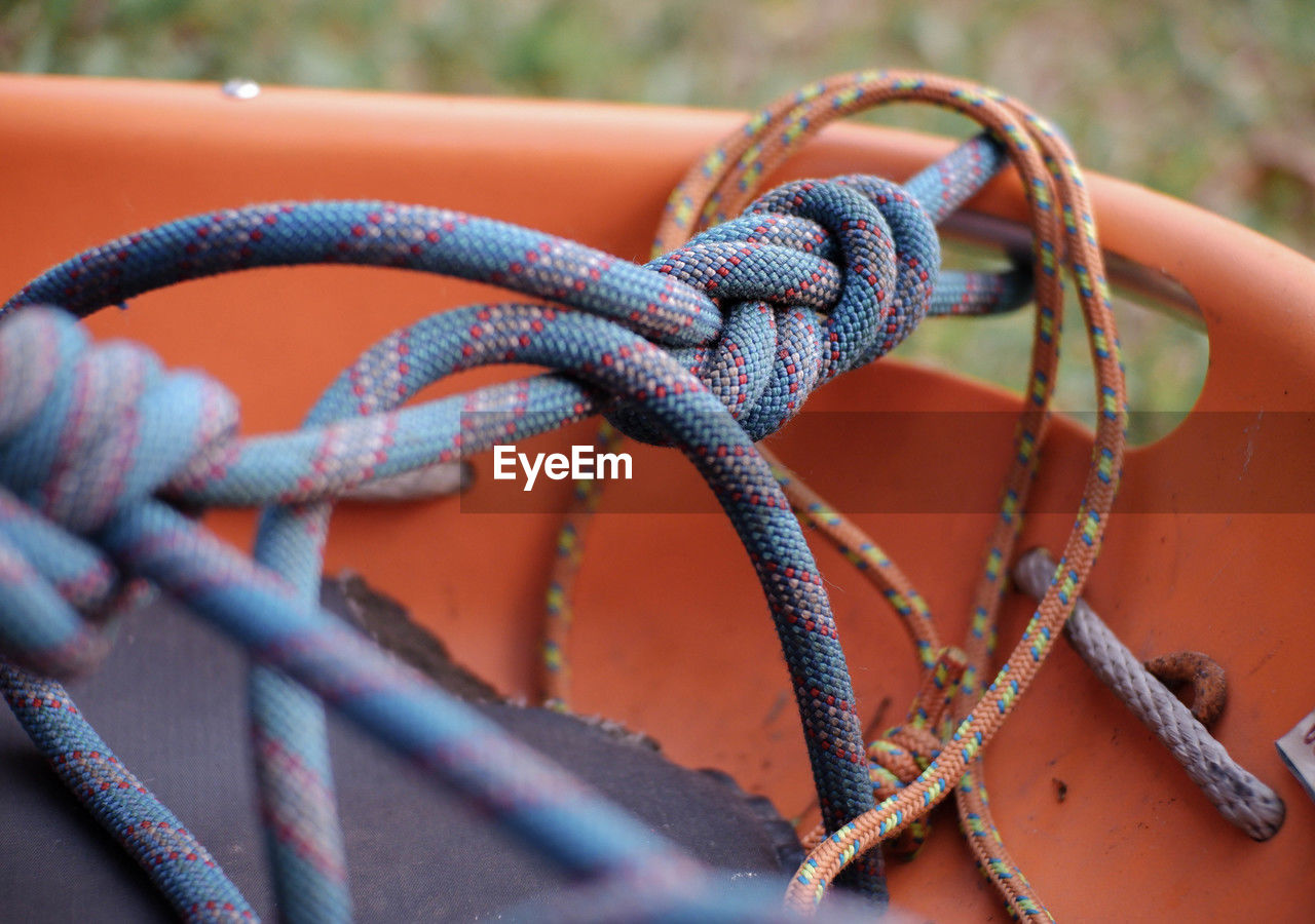 rope, close-up, metal, no people, knot, strength, red, tied knot, day, tied up, selective focus, blue, focus on foreground, protection, security, outdoors, nature