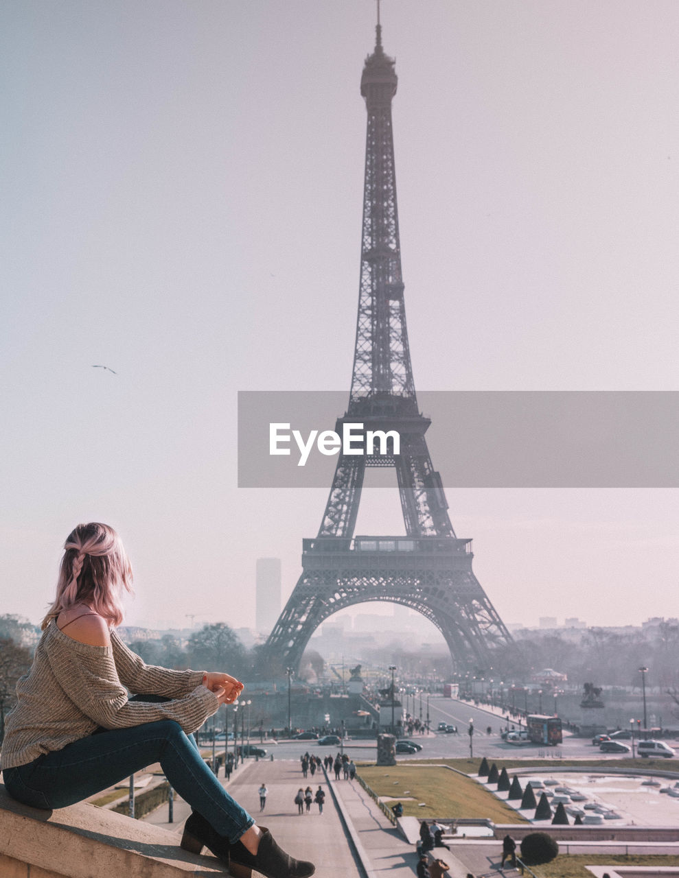 Woman looking at eiffel tower against sky