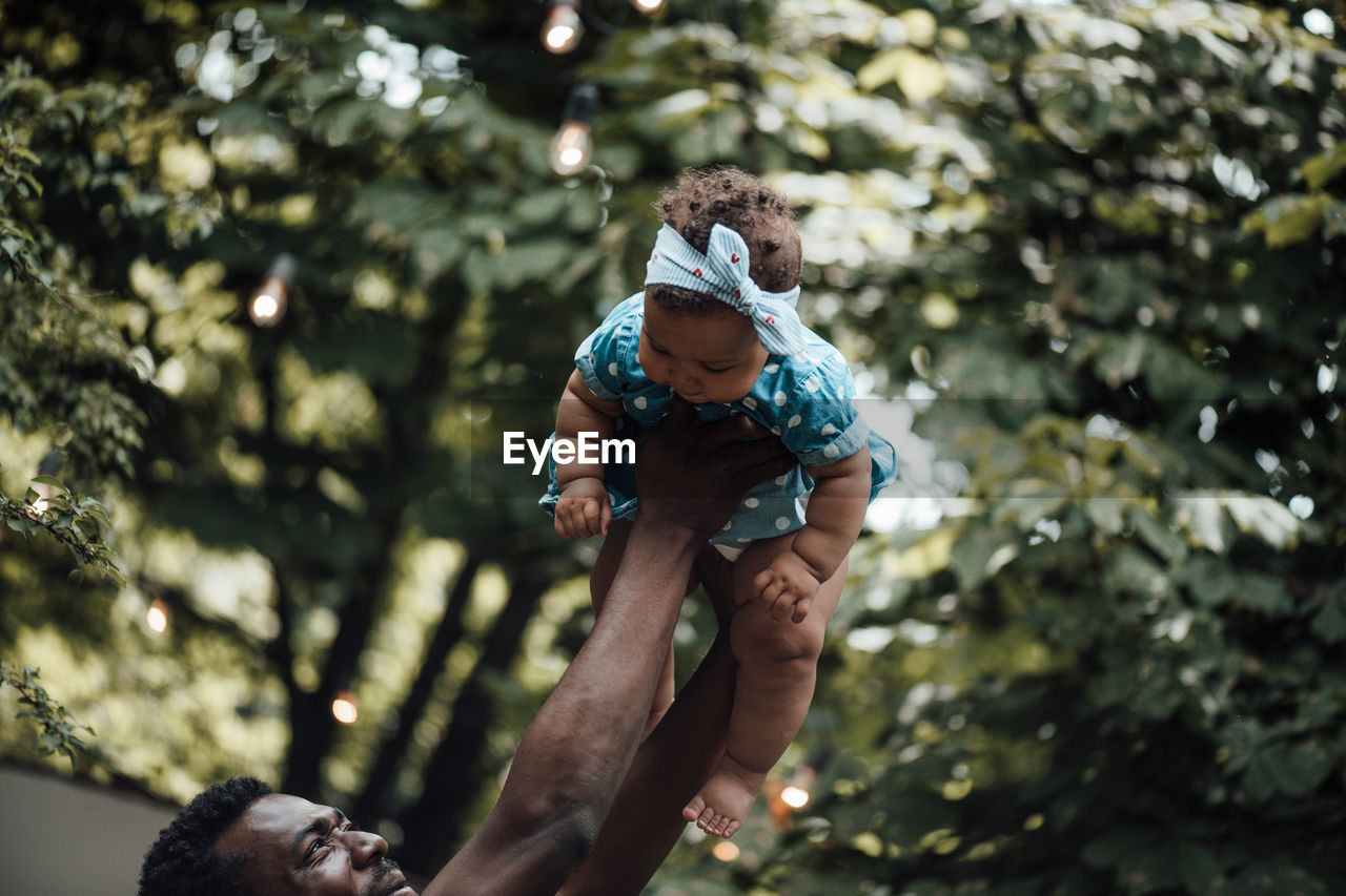 Father carrying daughter on shoulder outdoors