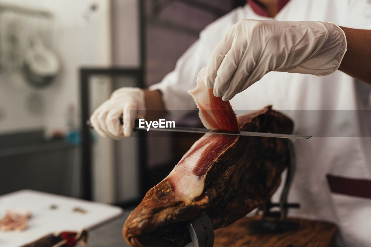 MIDSECTION OF MAN PREPARING MEAT