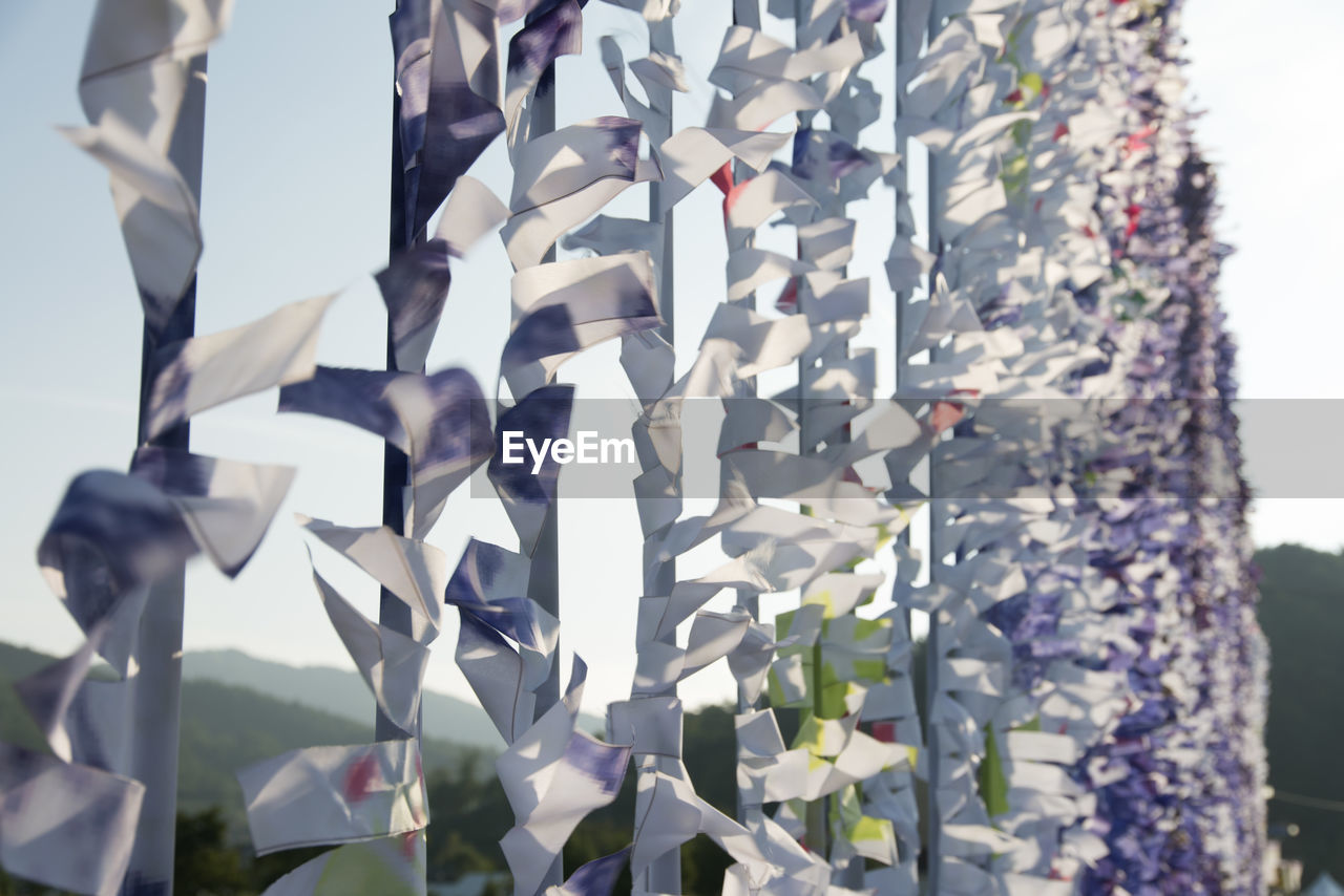 Close-up of fabrics hanging against sky