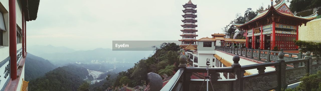 PANORAMIC VIEW OF BUILDINGS AND MOUNTAINS AGAINST SKY