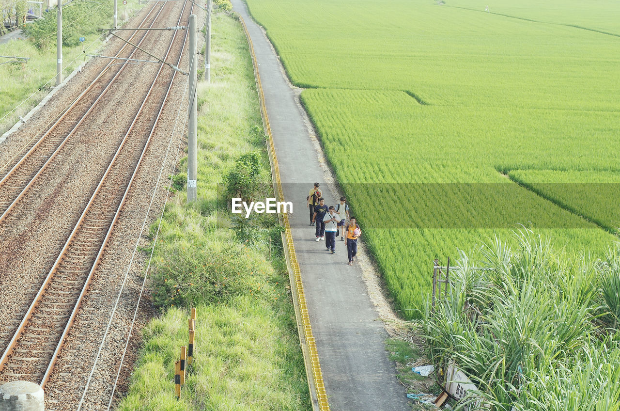 PEOPLE WALKING ON RAILROAD TRACKS