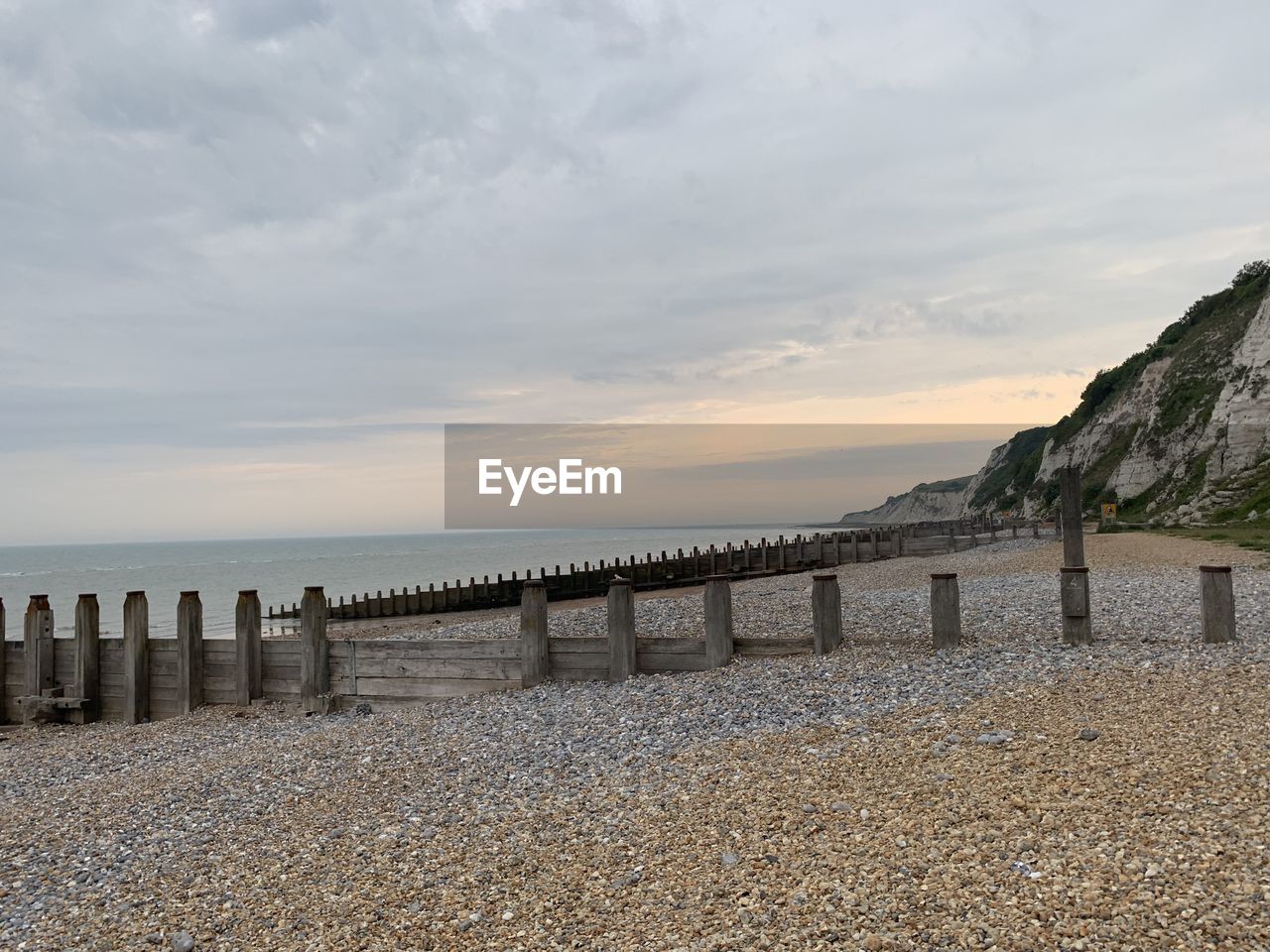 Wooden posts on beach against sky