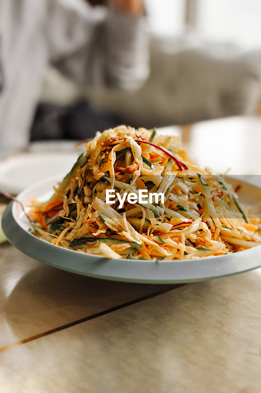 Asian chinese salad of cabbage, cucumber, carrot, noodles and sesame seeds. serving asian dishes