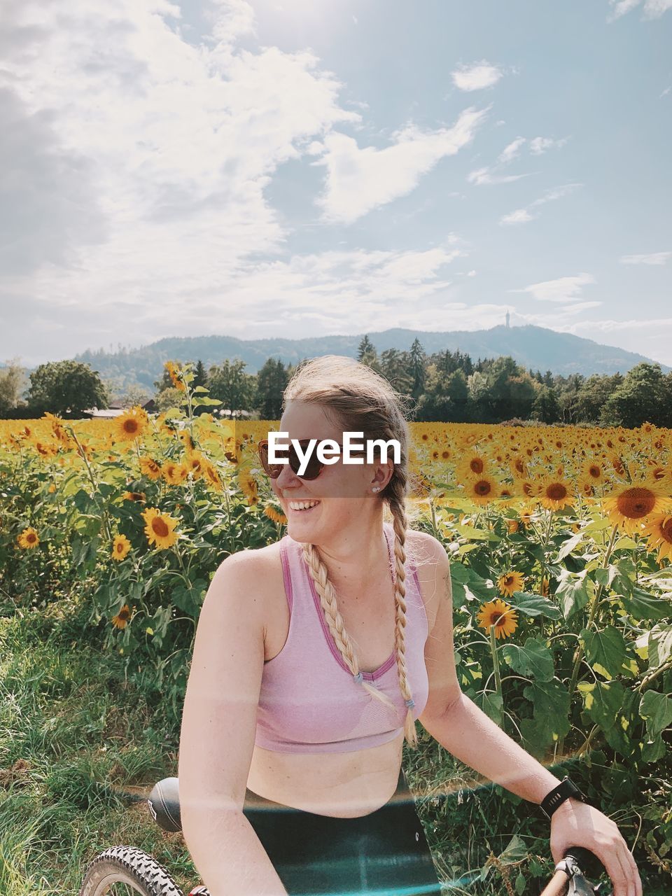 YOUNG WOMAN WEARING SUNGLASSES AGAINST SKY DURING SUNSET