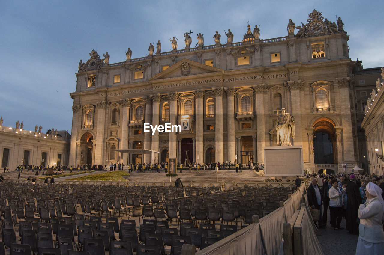 Seats arranged in front of st peters basilica in city at dusk
