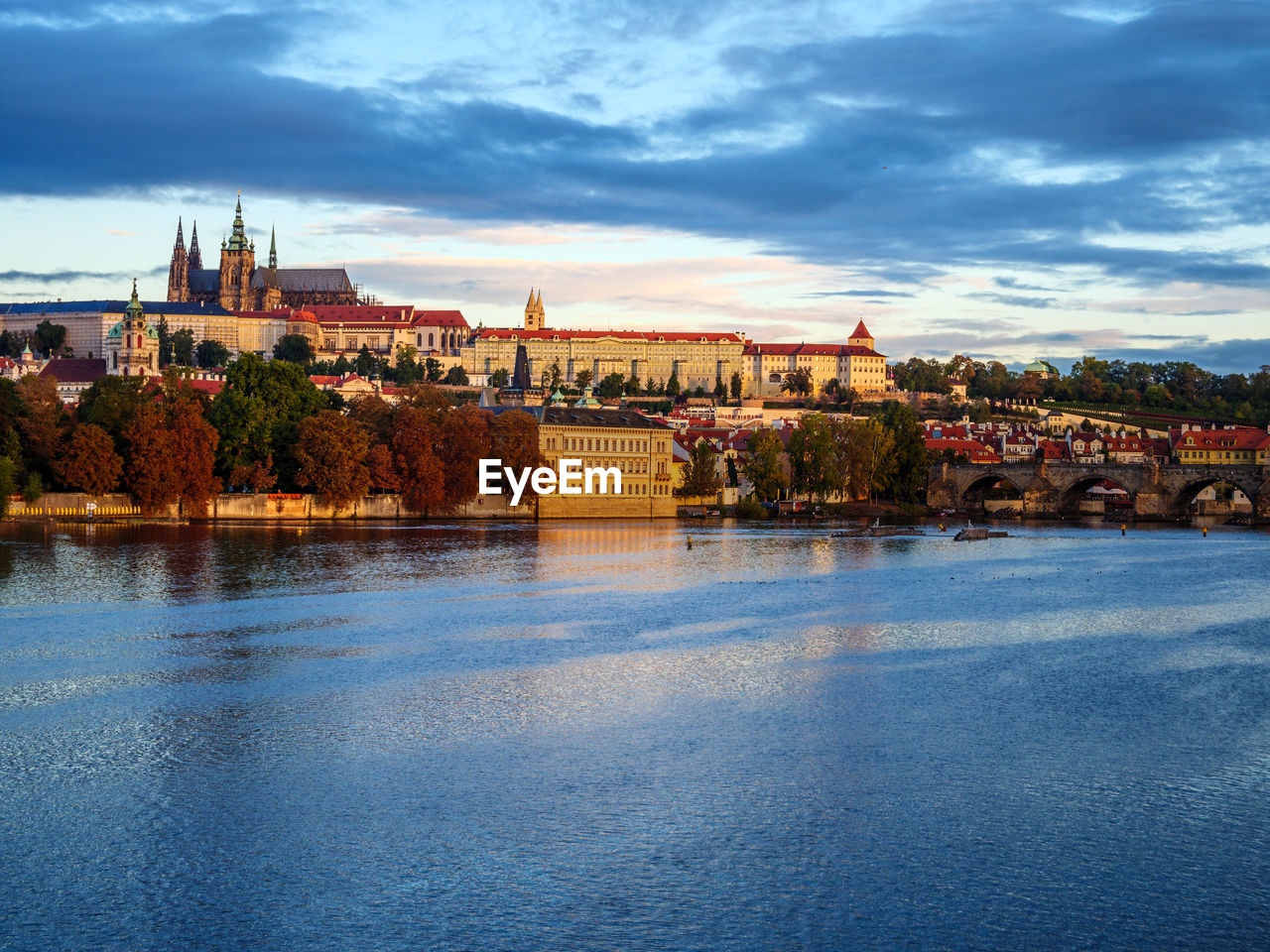 RIVER BY BUILDINGS IN CITY AGAINST SKY