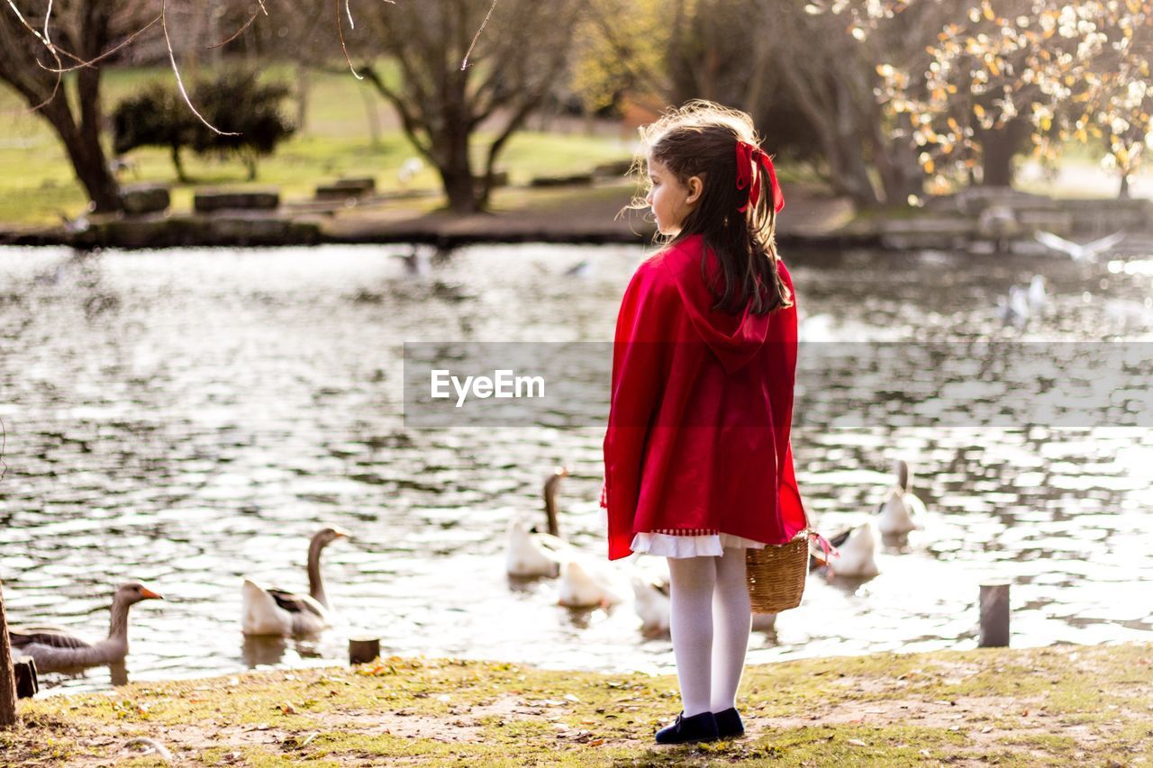 PORTRAIT OF BEAUTIFUL YOUNG WOMAN STANDING BY LAKE