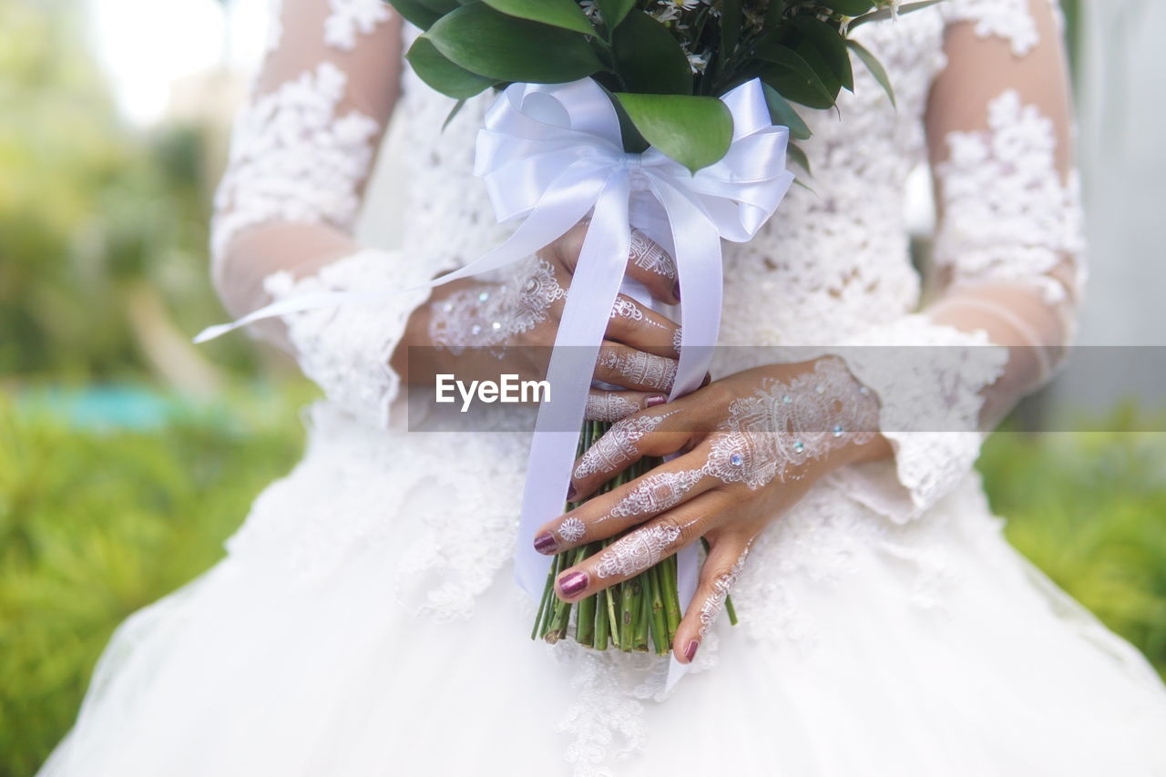 Close-up of woman holding bouquet of white flower