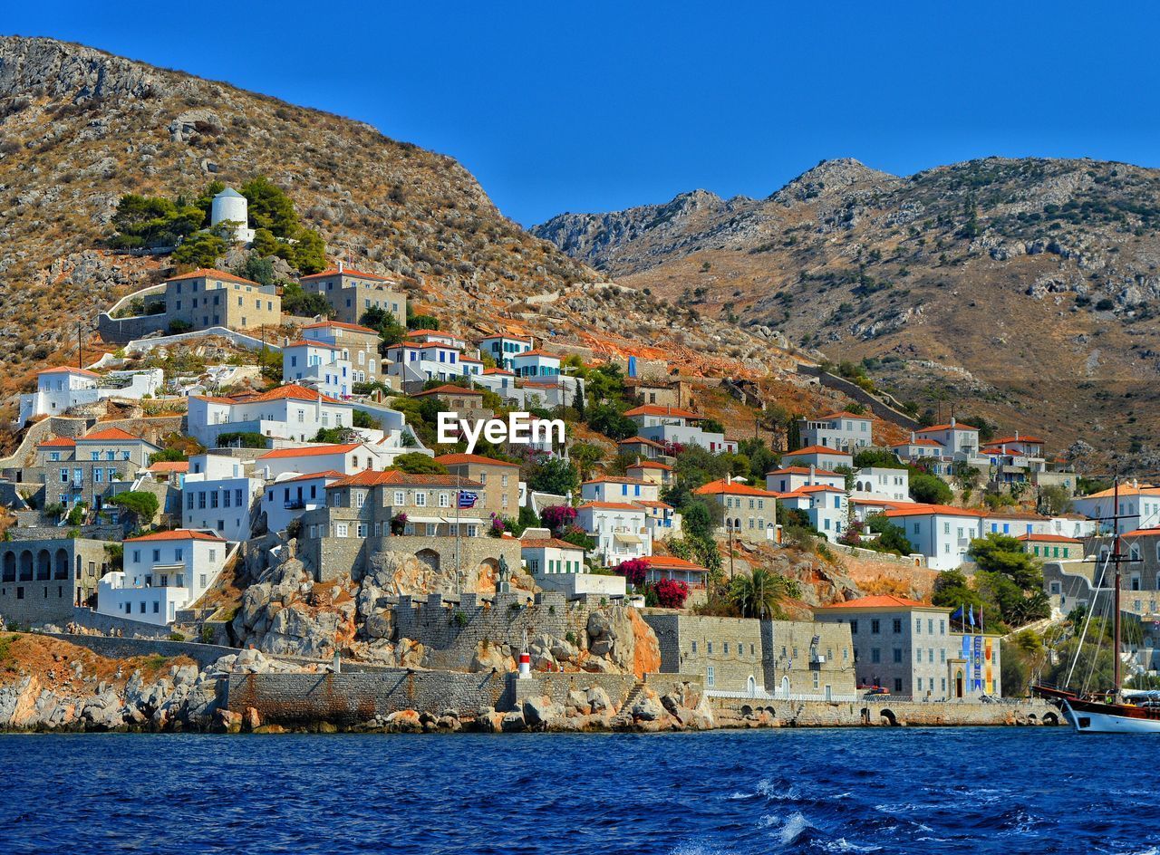 Town by sea against sky at hydra island