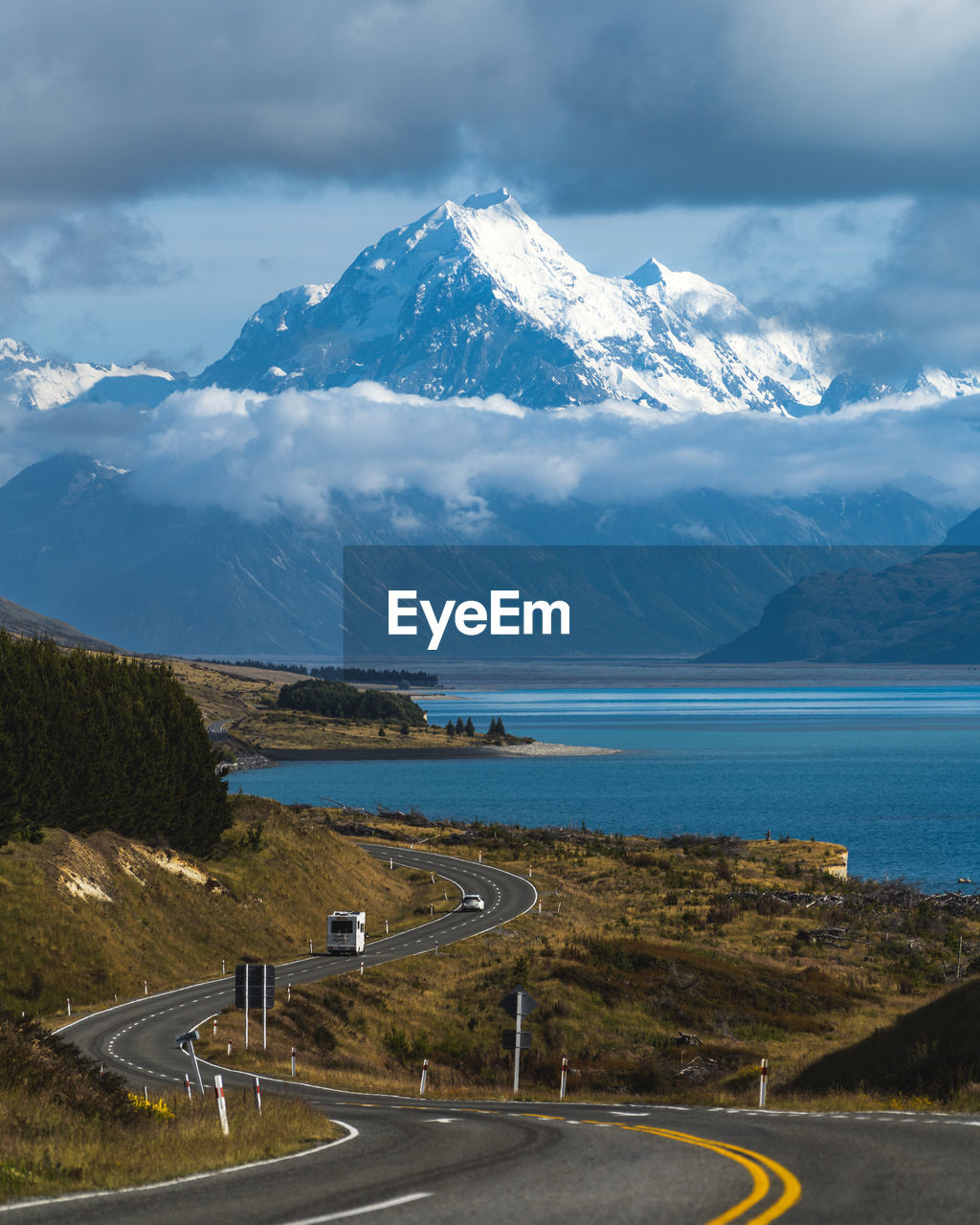 Winding road leading to snow capped mountain, mount cook, new zealand