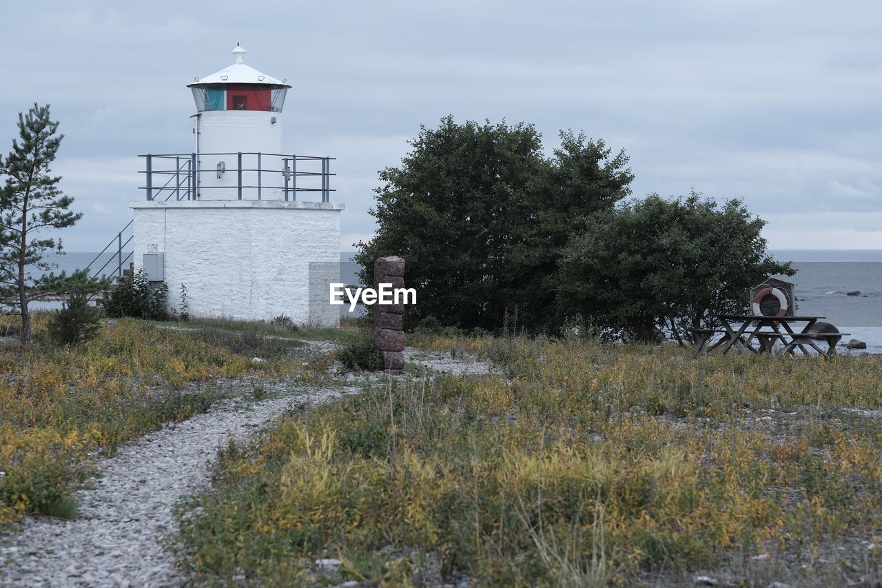 lighthouse, tower, architecture, plant, built structure, building exterior, sky, nature, water, building, security, protection, guidance, land, coast, cloud, tree, no people, sea, beach, day, grass, outdoors, scenics - nature, rural area, travel destinations, house, non-urban scene, landscape, tranquility