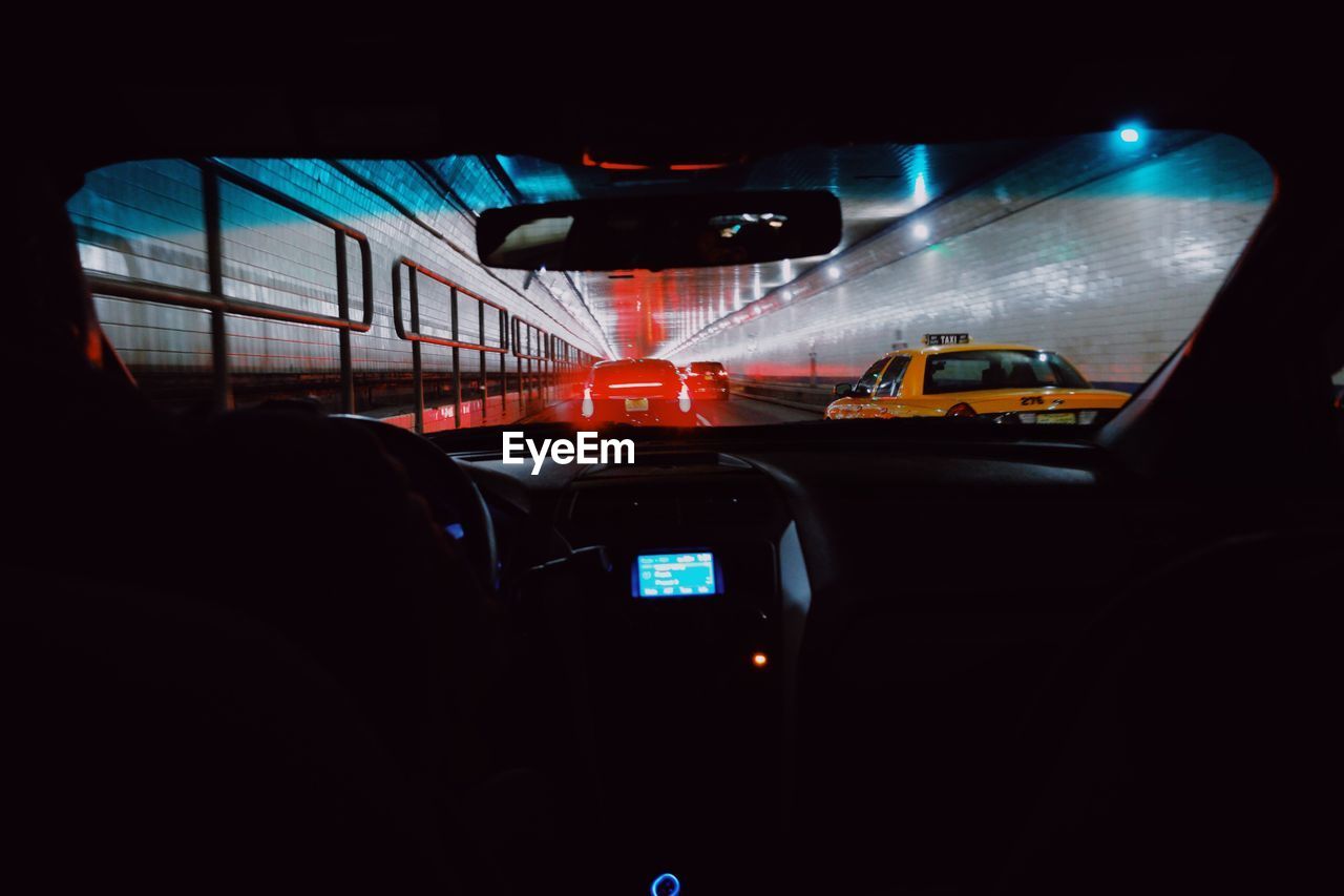 CLOSE-UP OF CAR MOVING IN ILLUMINATED BUS