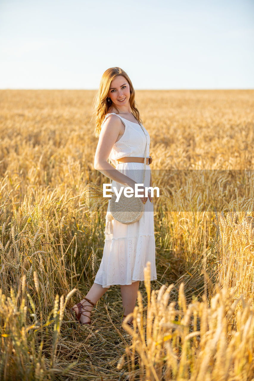 Portrait of smiling woman standing in field