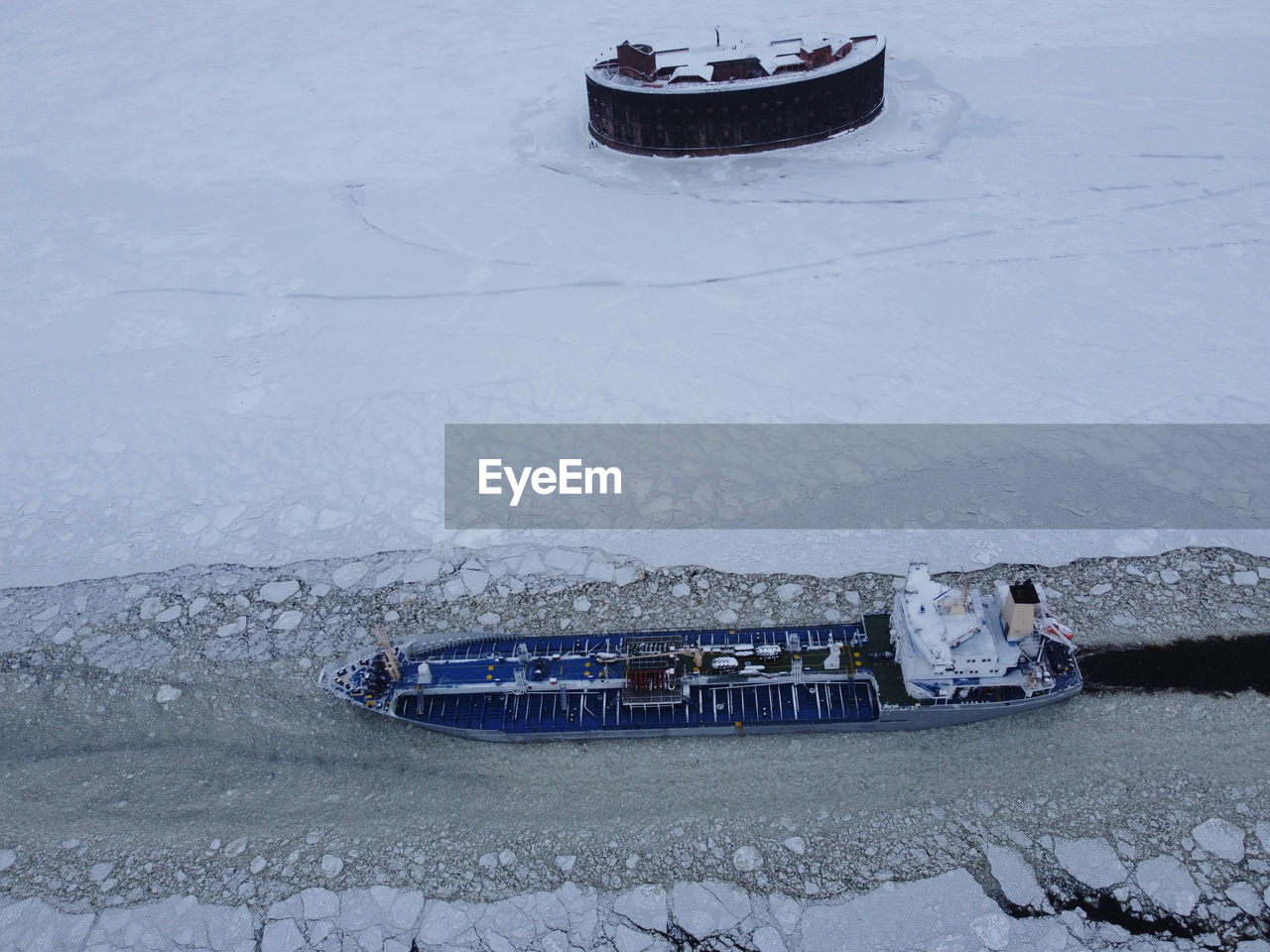 HIGH ANGLE VIEW OF FROZEN BOAT ON SNOW