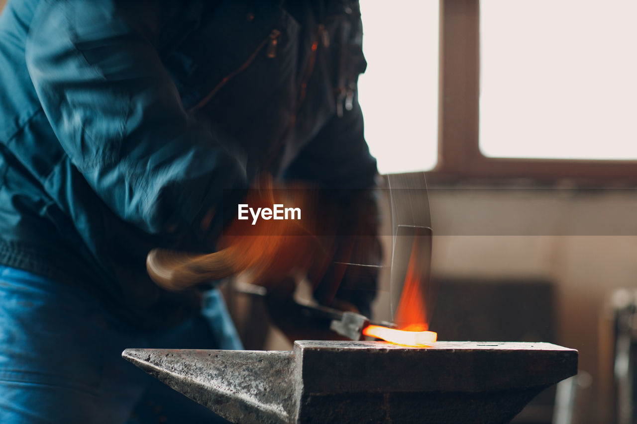 midsection of man working at factory