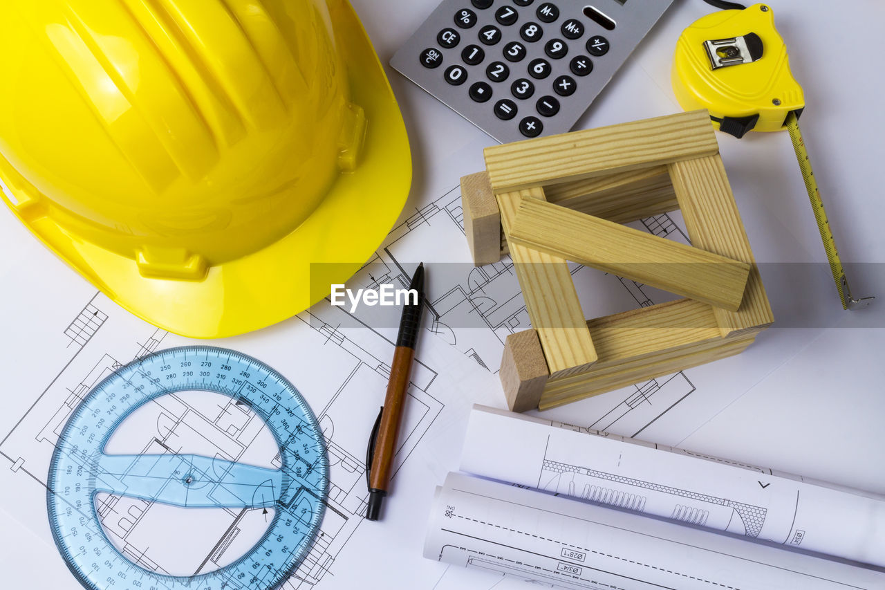 Directly above shot of equipment with hardhat on blueprint