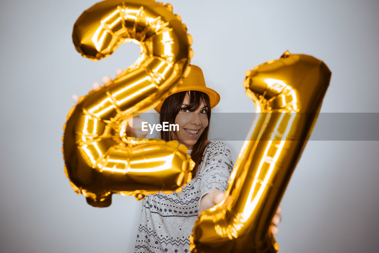 CLOSE-UP PORTRAIT OF A SMILING YOUNG WOMAN OVER WHITE BACKGROUND