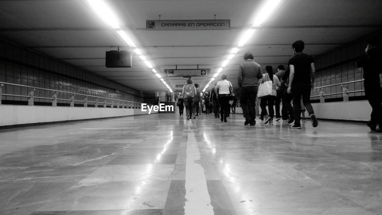 PEOPLE WALKING ON SUBWAY PLATFORM