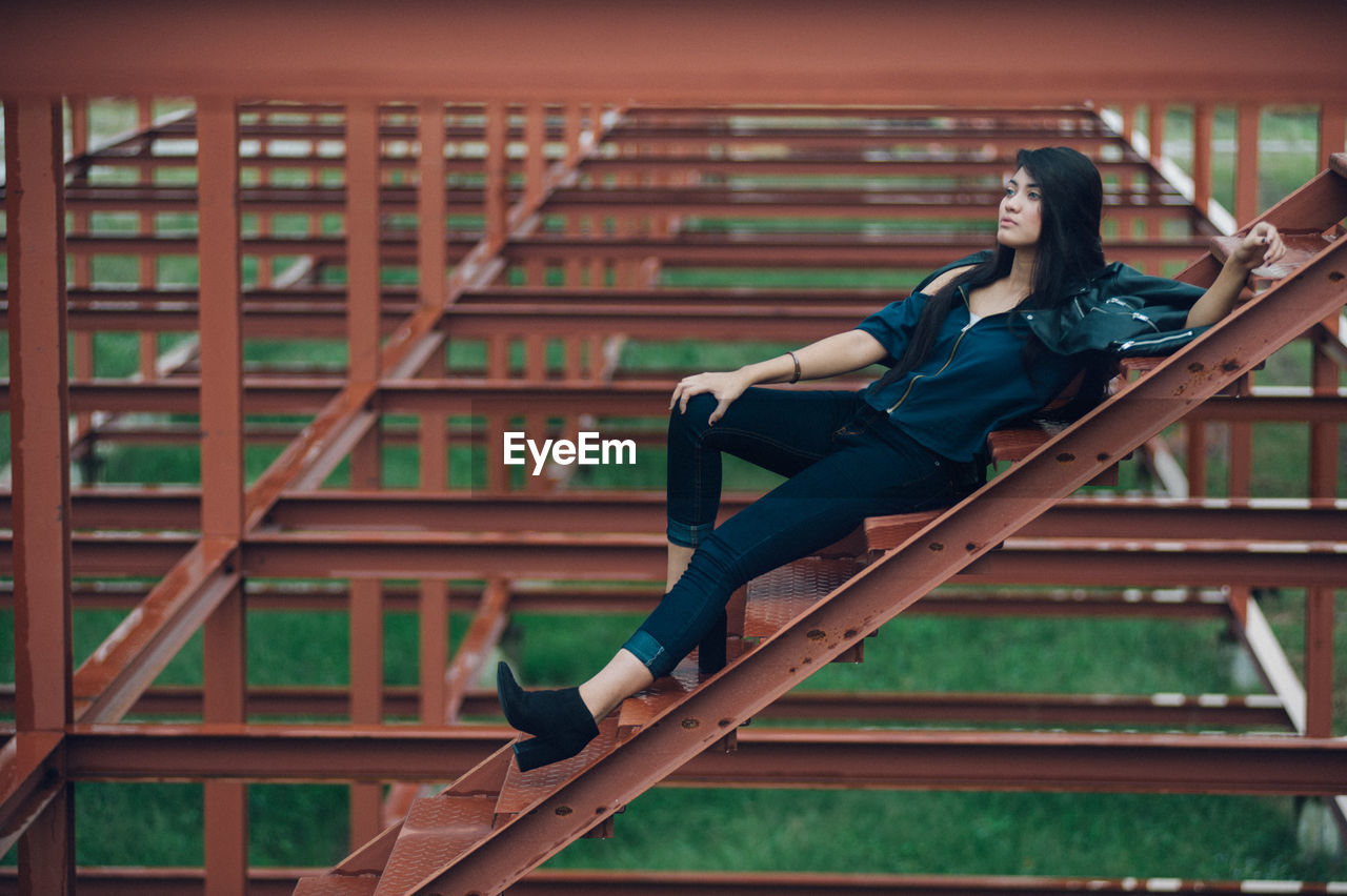 Full length of woman sitting outdoors