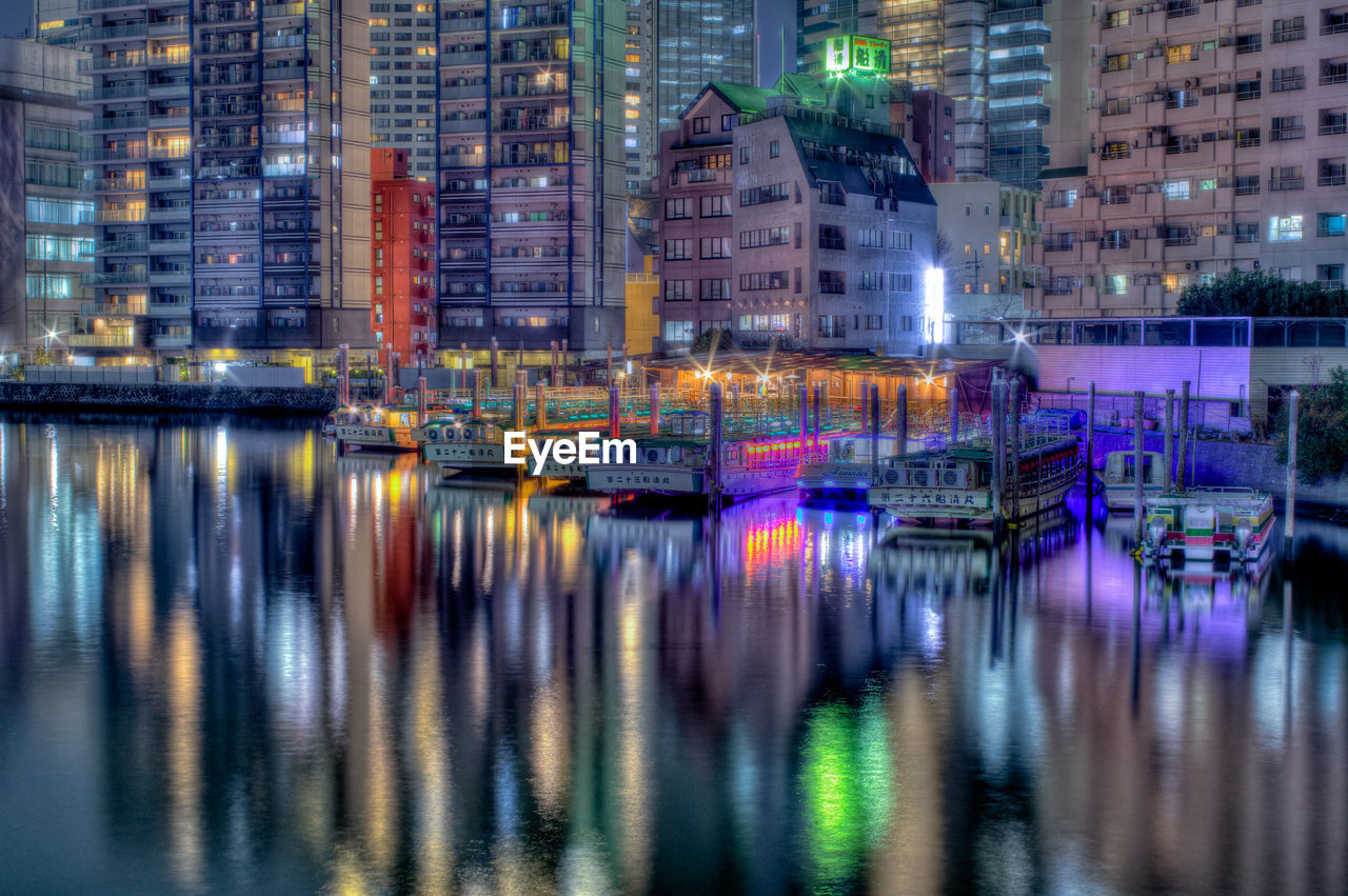 Reflection of buildings in city at waterfront