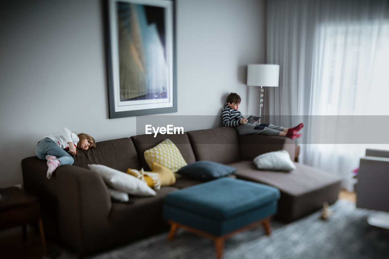 Siblings relaxing in the livingroom and doing some screentime