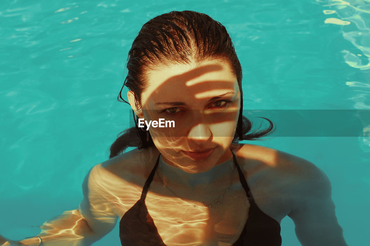 High angle portrait of young woman swimming in pool