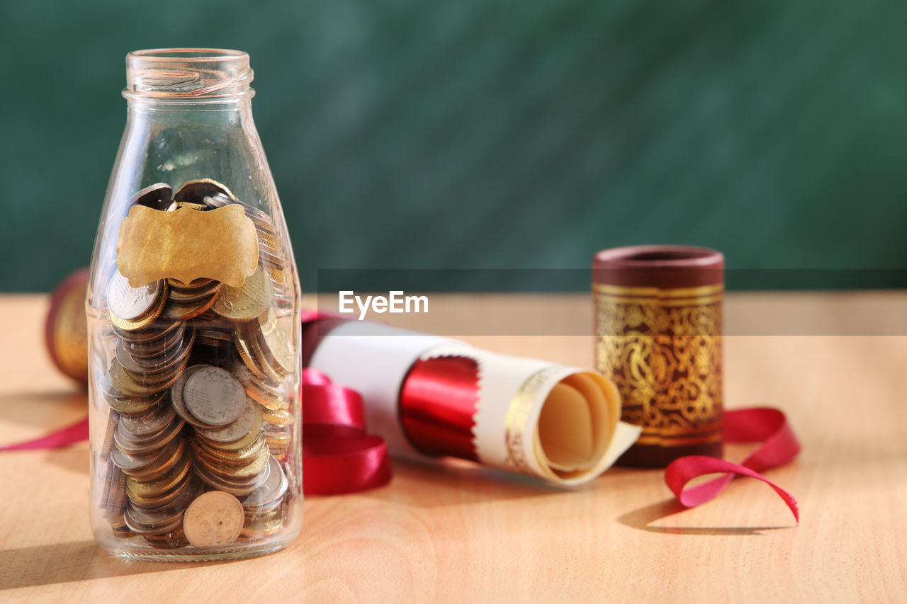 Close-up of document and coins on table