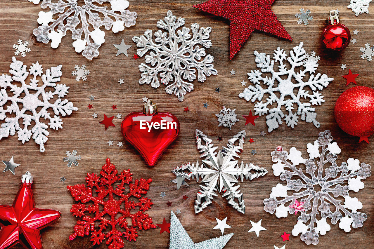 Christmas and new year background with christmas decorations and confetti on wooden table.