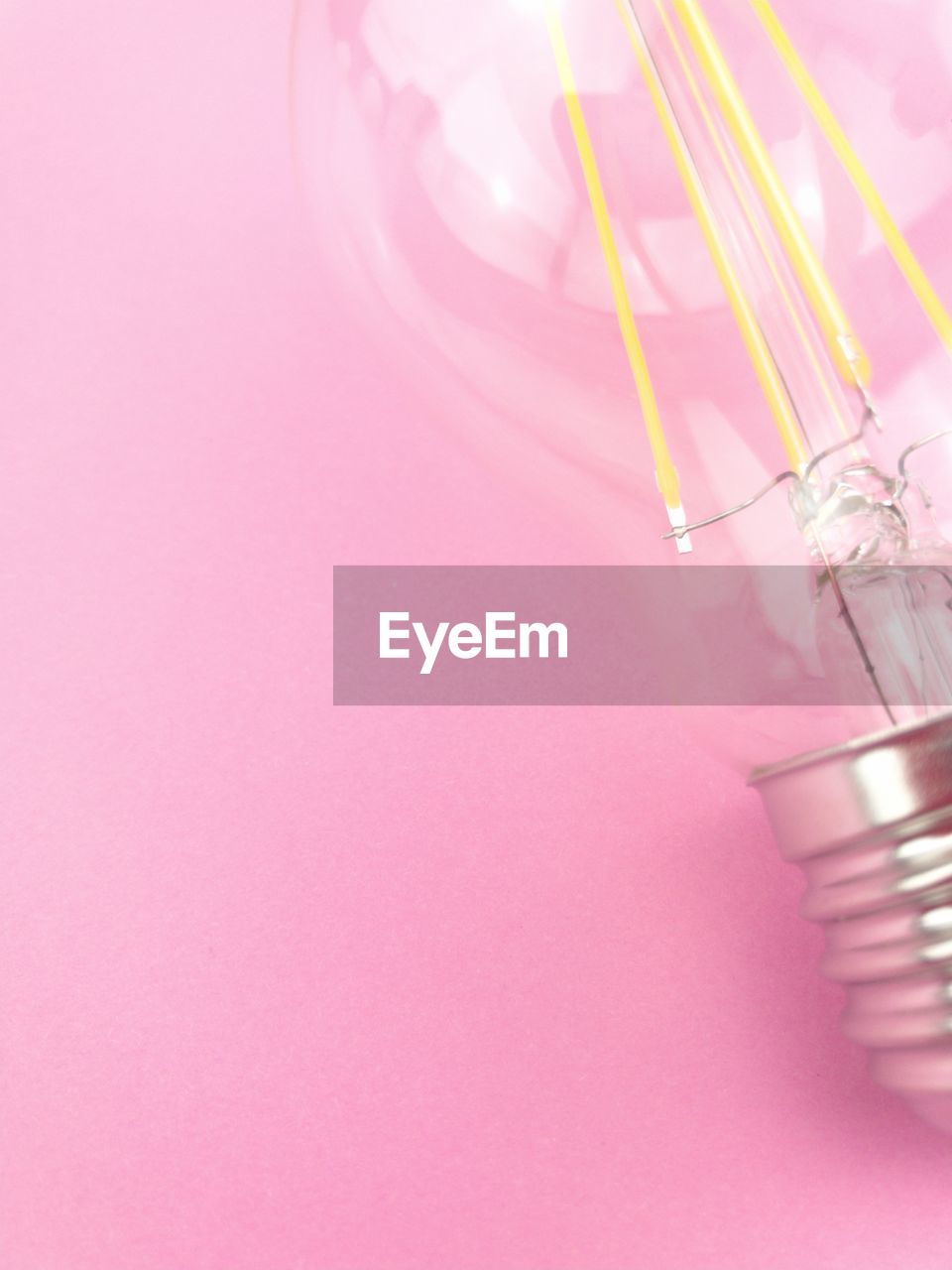 High angle view of light bulb over pink background