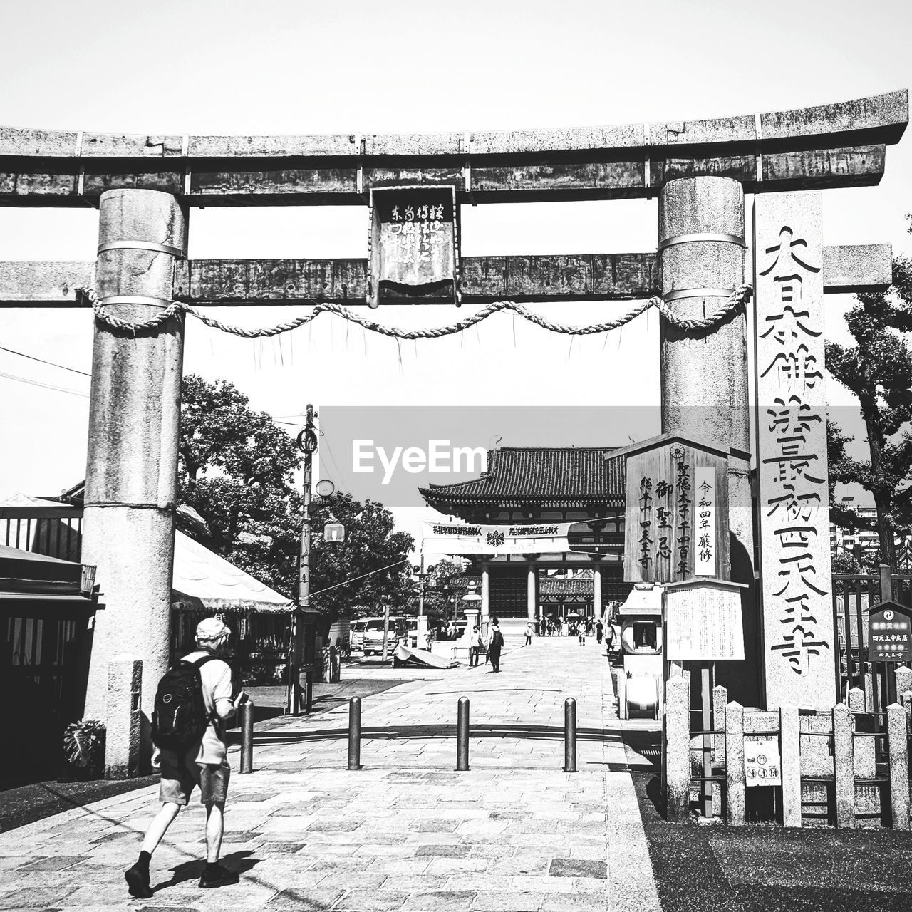 PEOPLE WALKING ON STREET AMIDST BUILDINGS AGAINST SKY