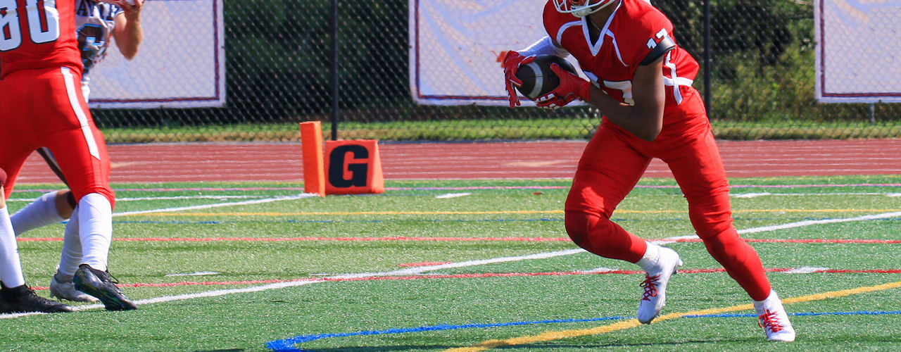 sports, player, competition, athlete, red, football player, clothing, ball game, american football, stadium, team sport, full length, adult, motion, grass, sports uniform, young adult, soccer, men, group of people, sport venue, competitive sport, headwear, sports equipment, playing field, sports clothing, cooperation