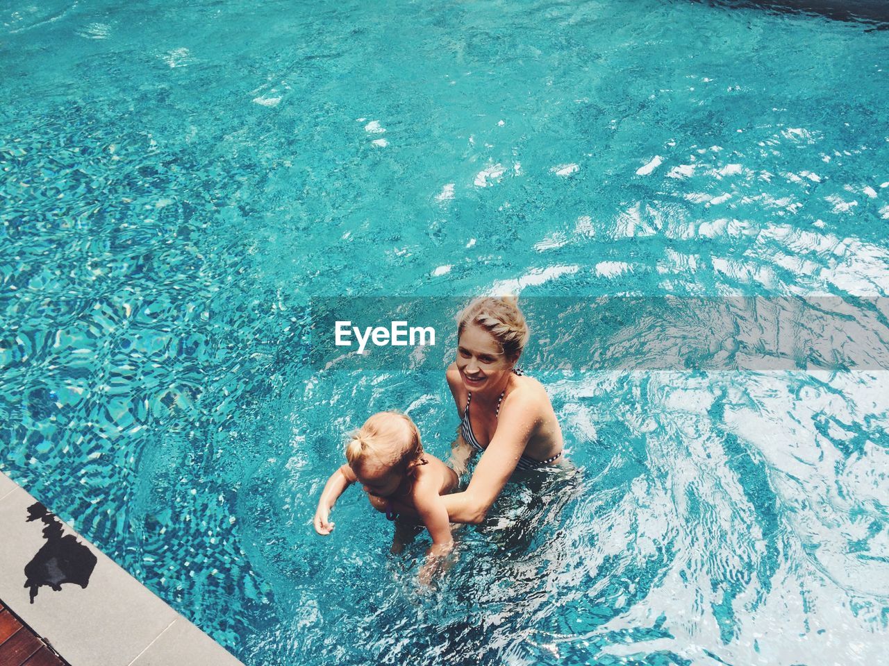 High angle view of mother with daughter in swimming pool