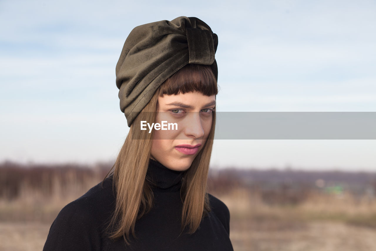 Portrait of young woman wearing headscarf against sky