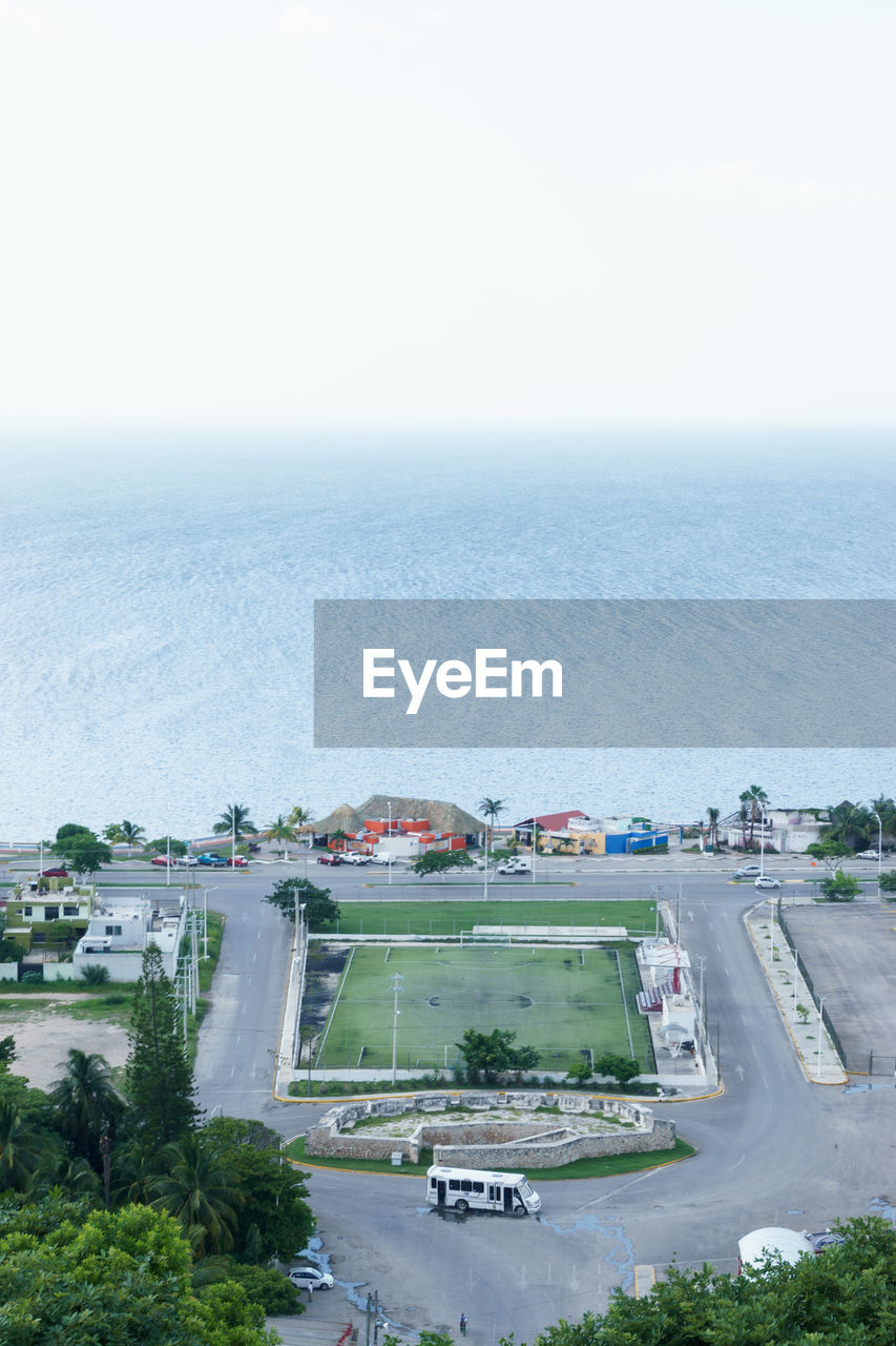 HIGH ANGLE VIEW OF CITY AGAINST SEA