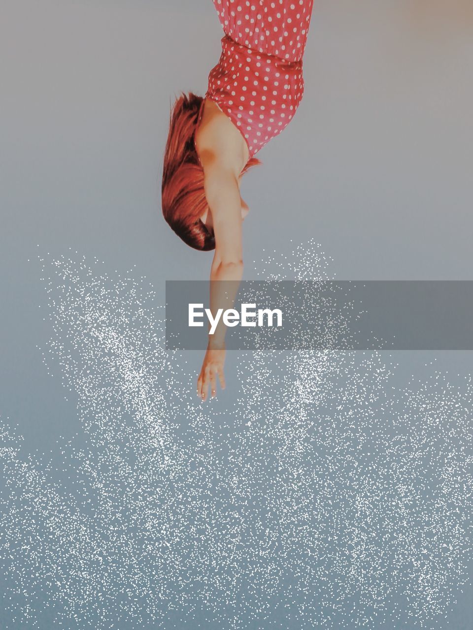 Low angle view of woman with arms raised standing against sky