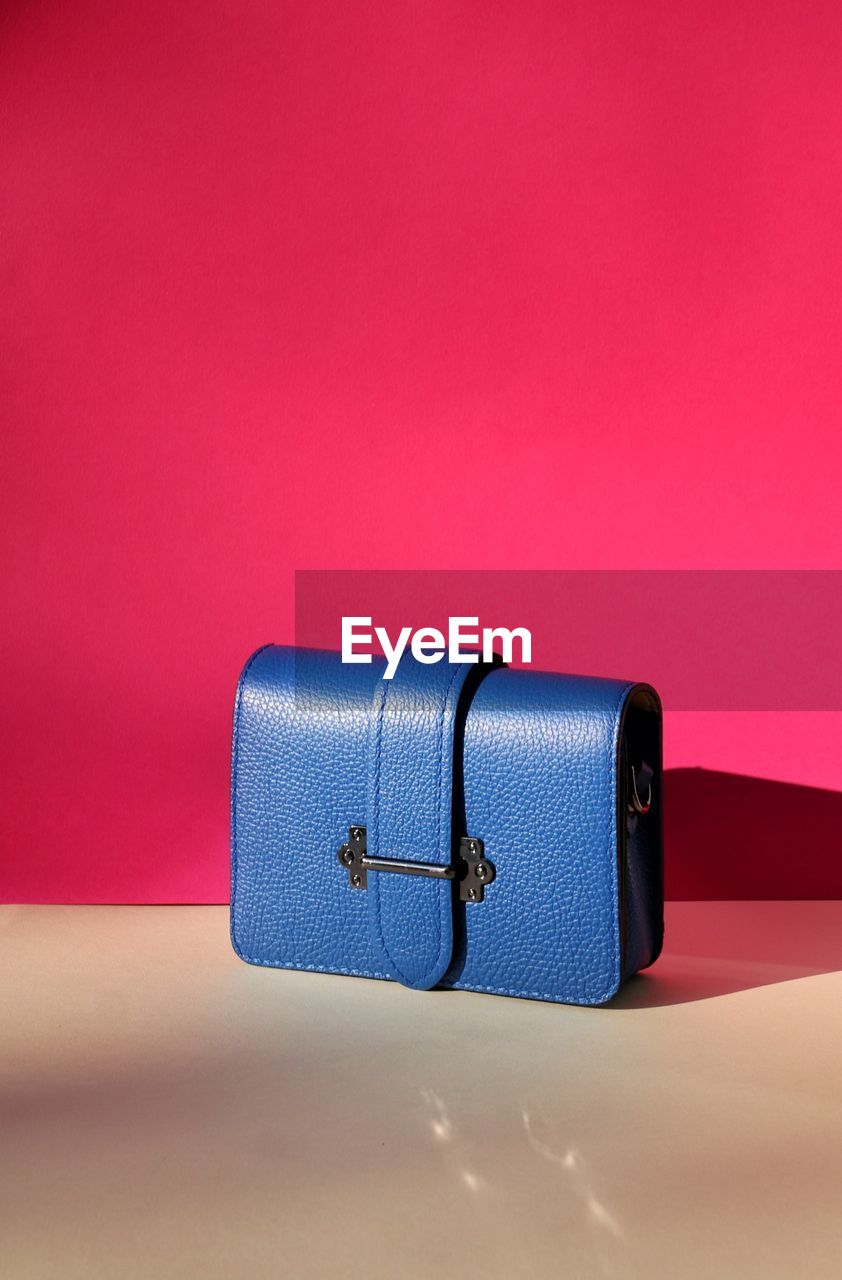  blue bag in front of red background