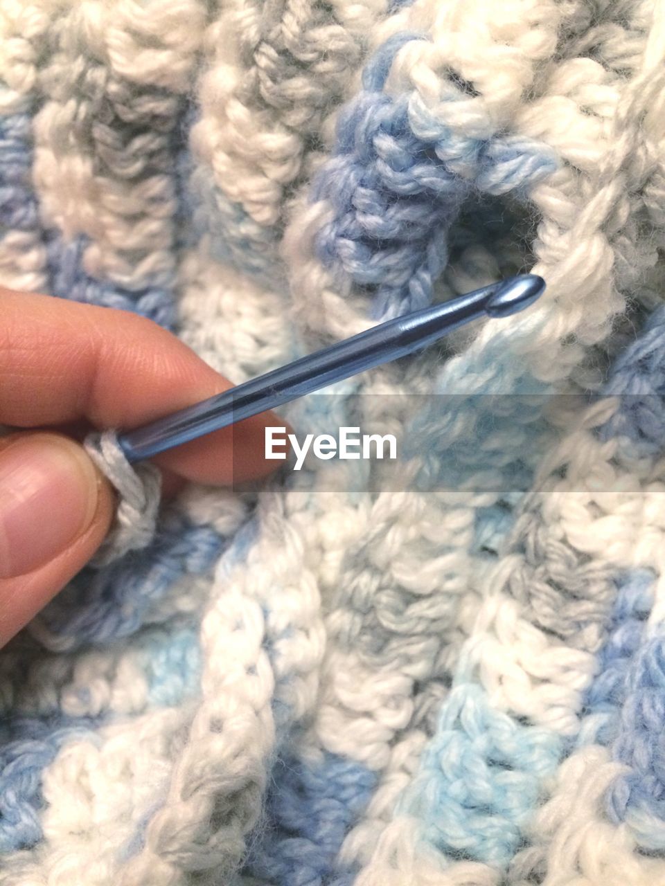 Cropped image of person knitting wool