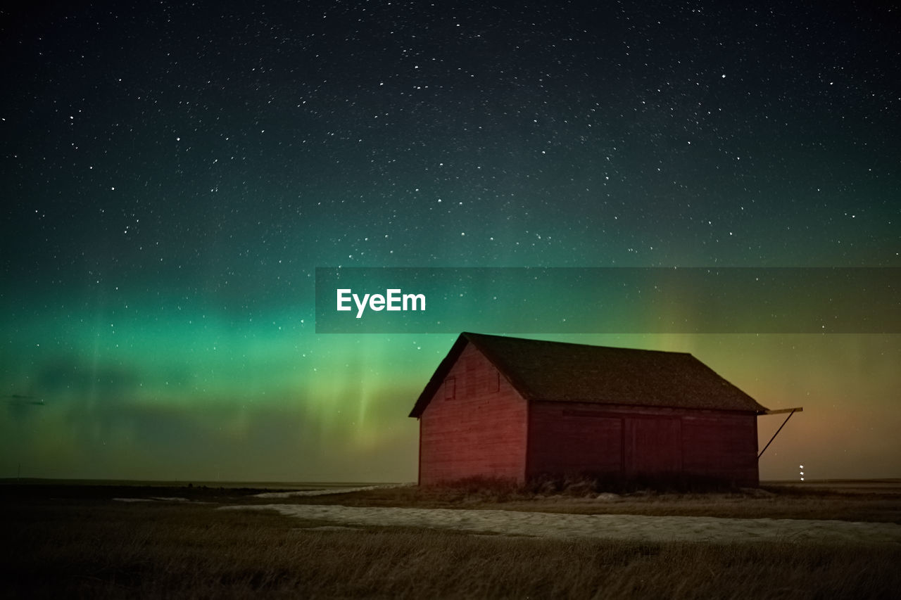 House on field against sky at night