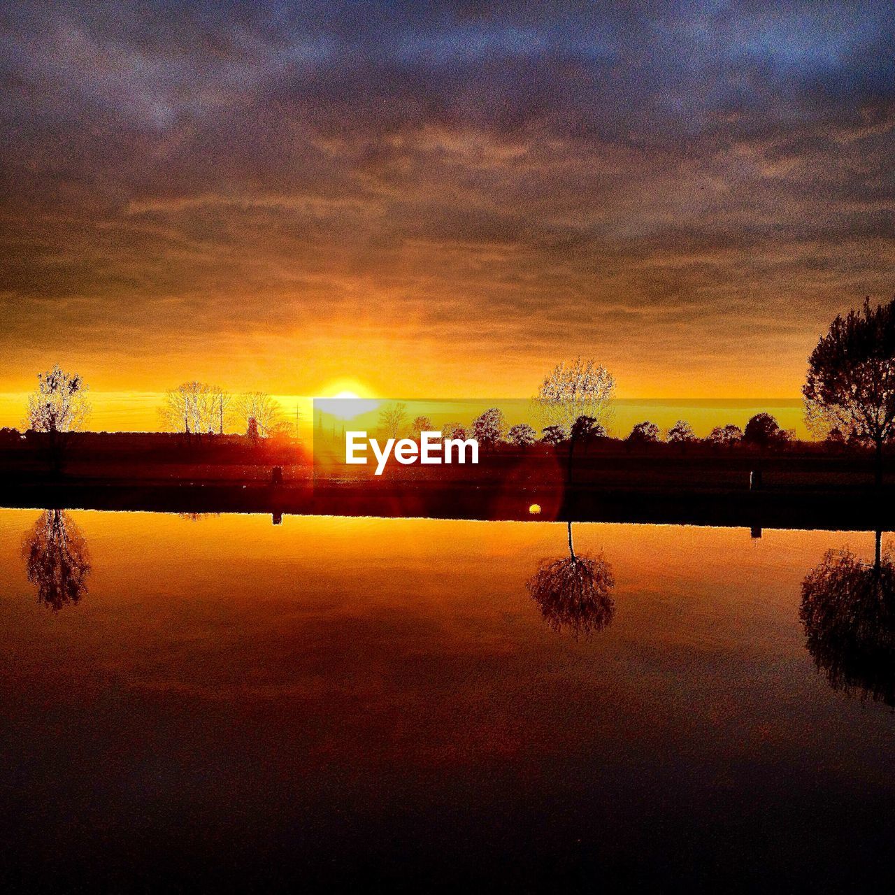 REFLECTION OF SUN IN LAKE DURING SUNSET