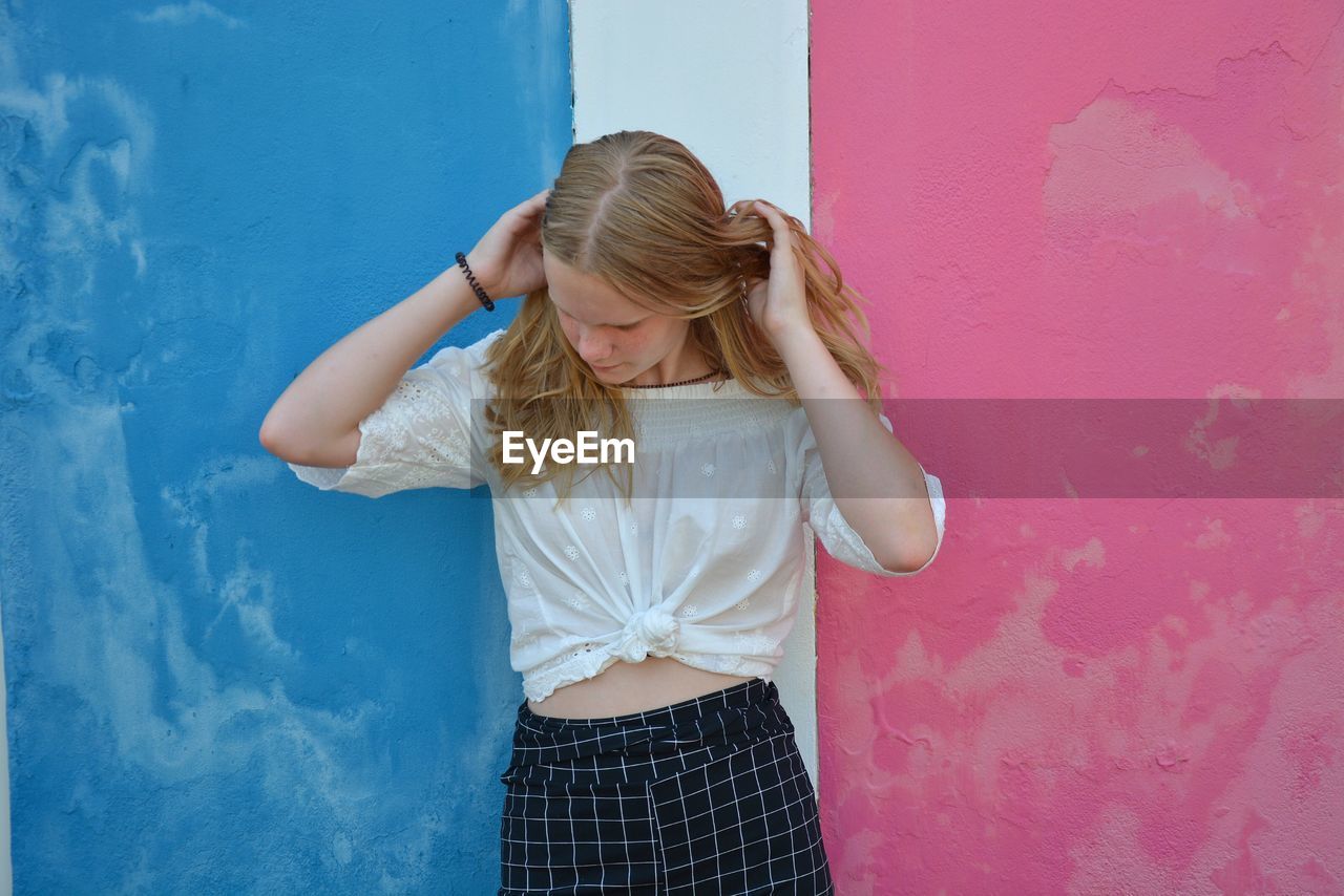 Teenage girl standing against colorful wall