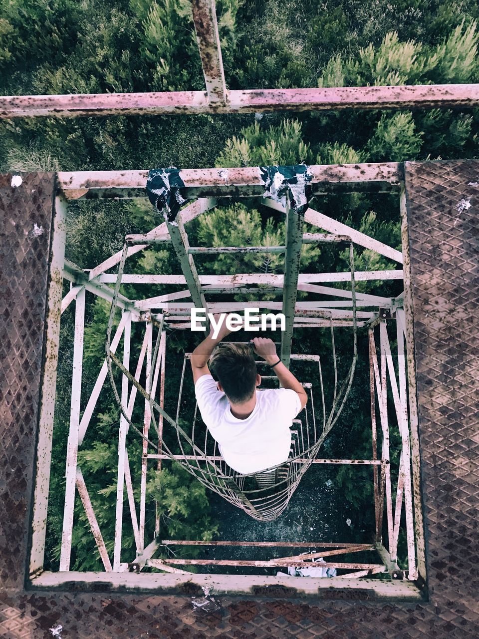 High angle view of man moving down on ladder