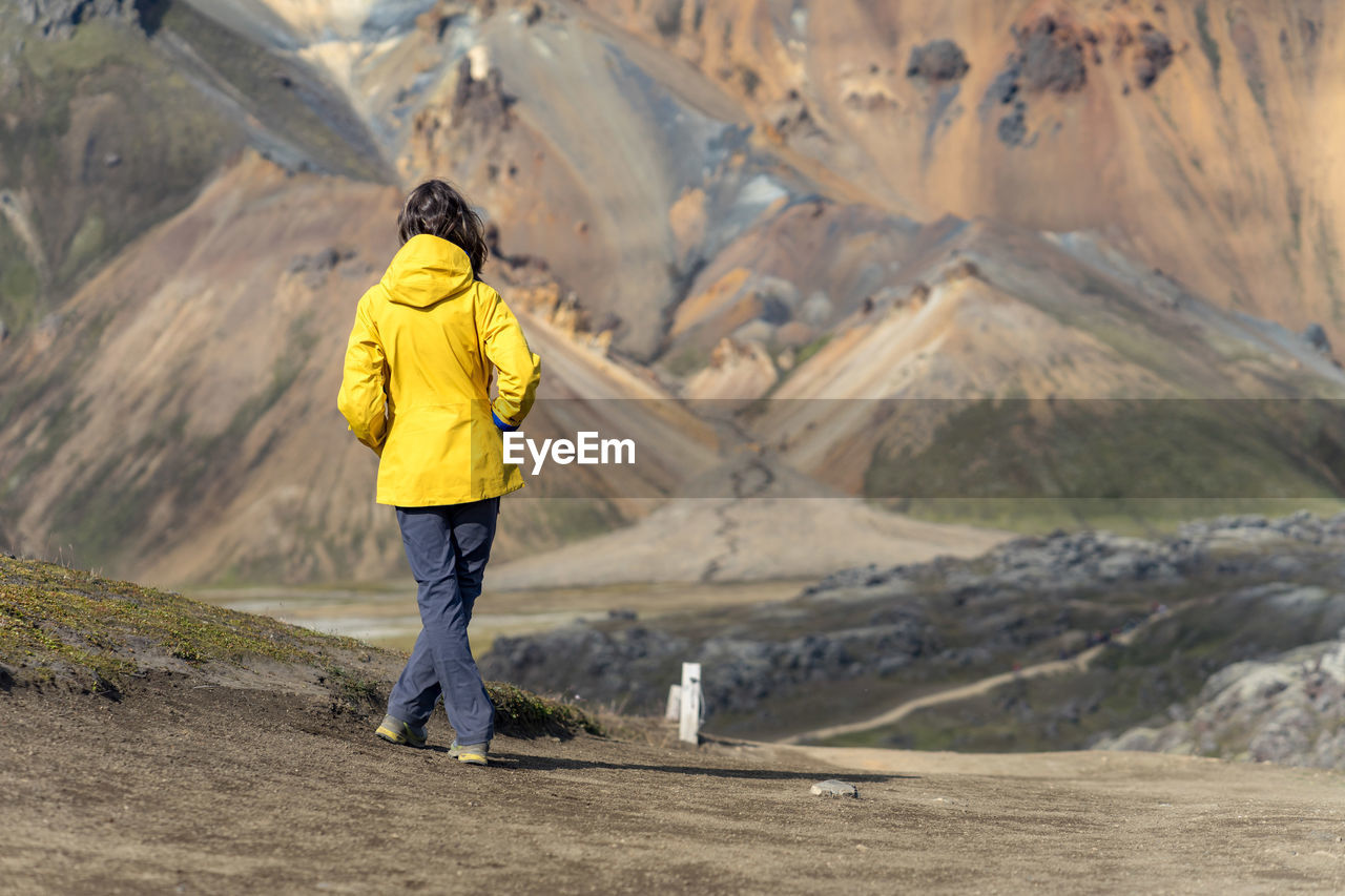 Young woman is admiring iceland's foreign volcanic landscape