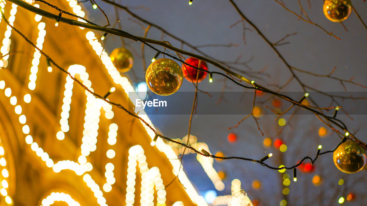 LOW ANGLE VIEW OF ILLUMINATED CHRISTMAS TREE