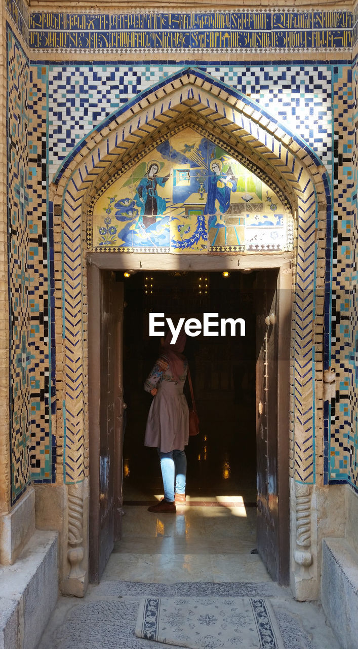 REAR VIEW OF WOMAN WALKING IN CORRIDOR